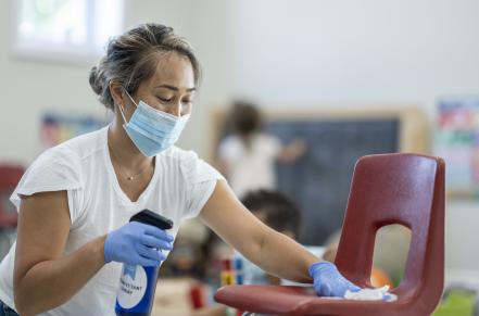 Woman cleaning a chair with a disinfectant