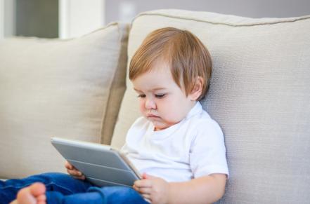Toddler staring at a tablet