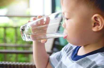 Child drinking water out of a glass