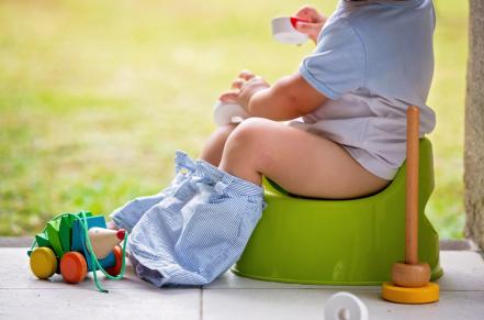 Child on small potty outdoors
