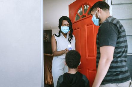 Provider checking child's temperature at front door