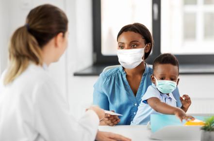 Masked parent and child at doctor