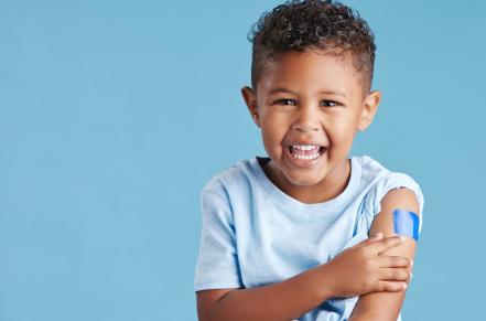 Child with bandaid on arm after immunization