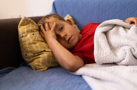 child laying on couch sick