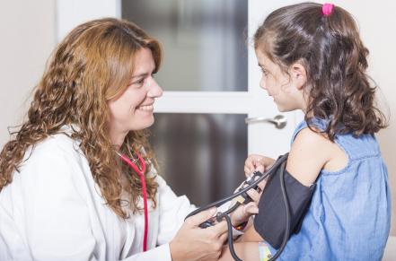 Doctor taking child's blood pressure