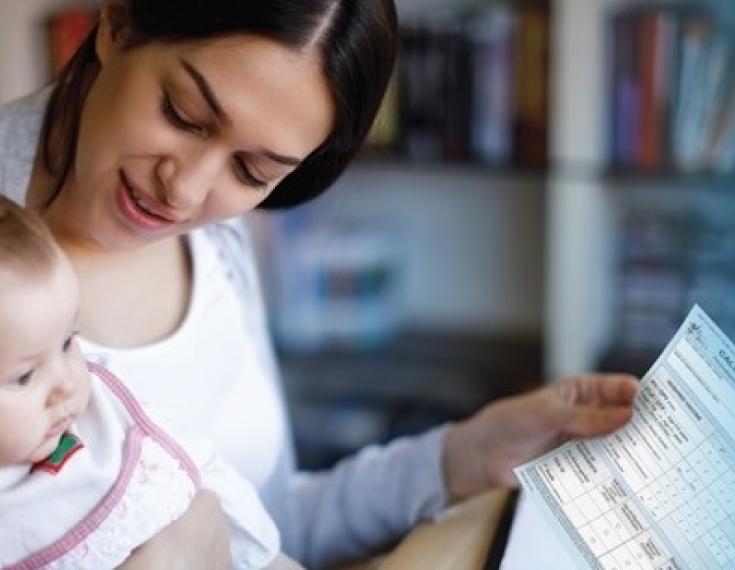 Woman holding baby and form.