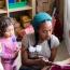 Child care provider reading to 3 children