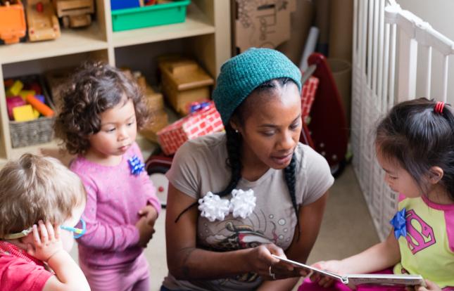 Child Care Provider reading to 3 children