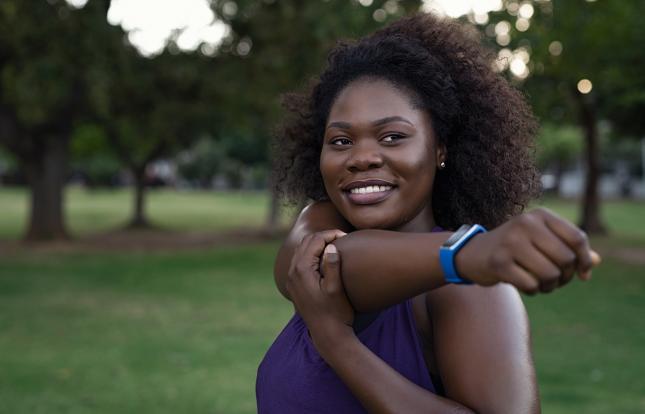 Person stretching outdoors with a smile