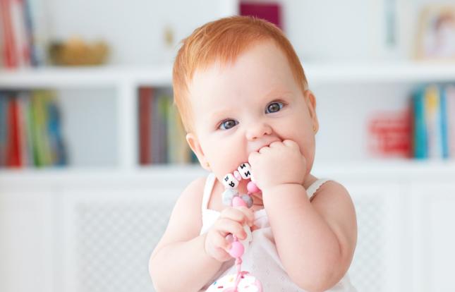 Child with their hand in their mouth, looks like they're biting it