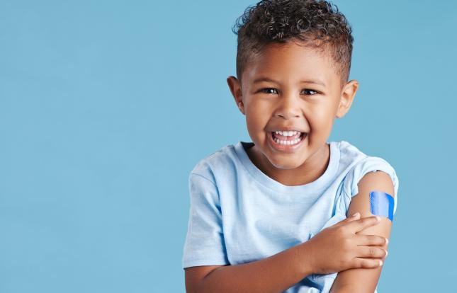 Child with bandaid on arm after immunization