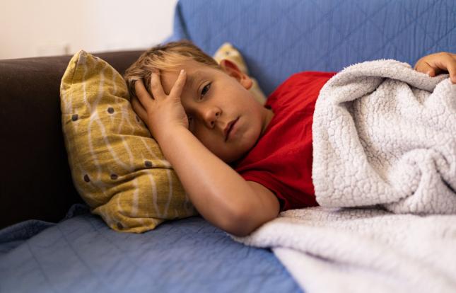child laying on couch sick