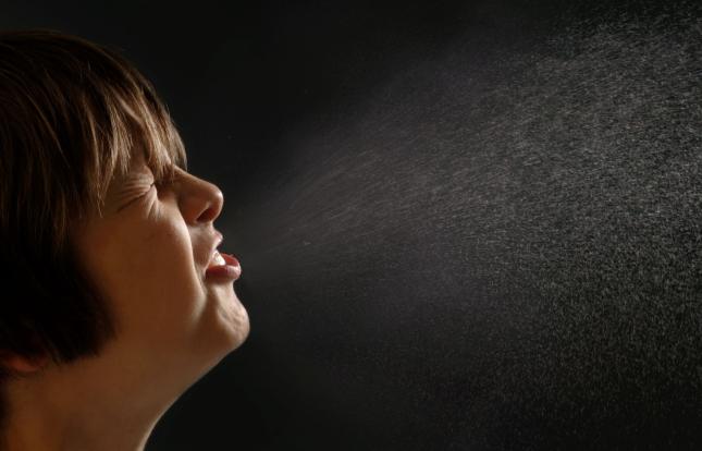 Child sneezing with droplets spraying