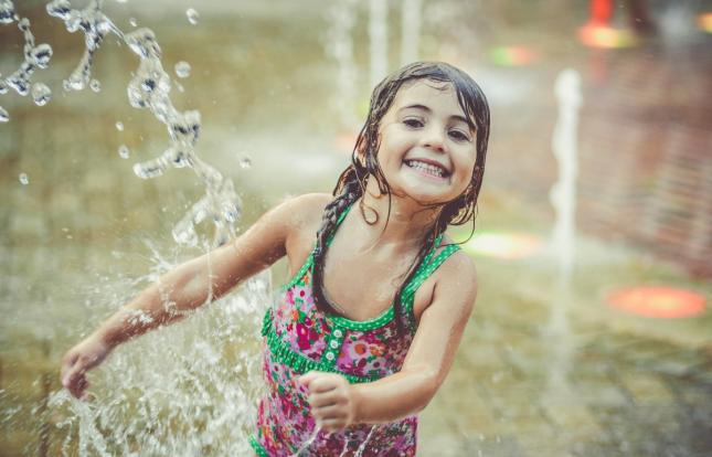 Child playing in a sprinkler or splash park